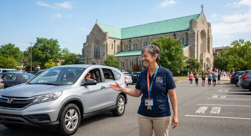 A welcoming scene at the church parking lot. A friendly volunteer wearing a bright lanyard is smiling and directing a car. The background shows the beautiful green roof of the cathedral. The lighting is bright and cheerful.